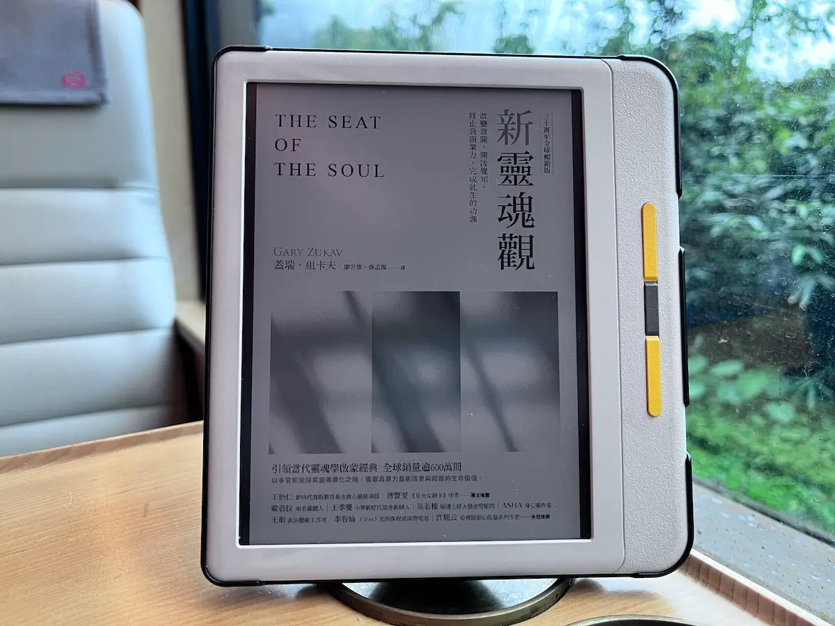 在檜木打造的列車福森號的木桌上立著一個電子書閱讀器，電子書的封面是新靈魂觀